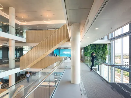 Contemporary office design with open staircases and glass railings Modern workplace interior with open staircases, glass railings, and large windows