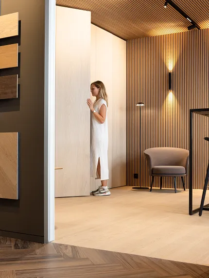 Light Wood Look Luxury Vinyl Flooring in Modern Room Design Modern room with light wood look luxury vinyl flooring and wall panels, featuring a woman in a white dress