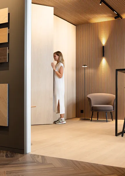 Light Wood Look Luxury Vinyl Flooring in Modern Room Design Modern room with light wood look luxury vinyl flooring and wall panels, featuring a woman in a white dress