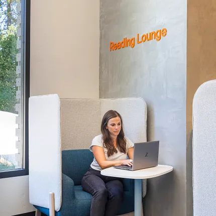 Education Facility Reading Lounge with Commercial Carpet Tile Flooring Woman working on a laptop in a reading lounge with commercial carpet tile flooring, 9x36 inch, Education Facility