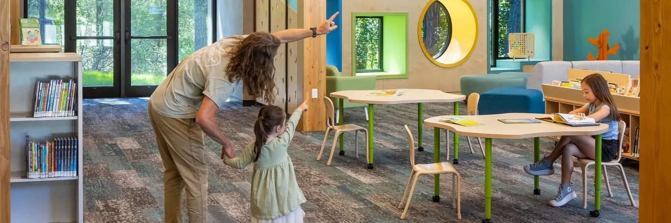 Education facility with commercial carpet tile flooring in shades of blue and gray, featuring wooden beams and modern lighting