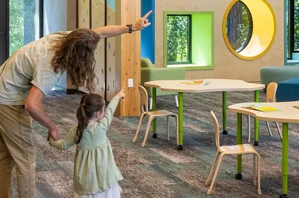 Education Facility with Commercial Carpet Tile Flooring and Wooden Beams Education facility with commercial carpet tile flooring in shades of blue and gray, featuring wooden beams and modern lighting