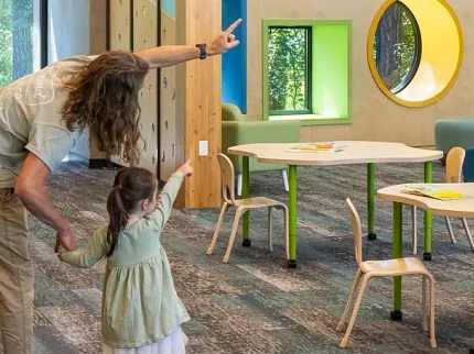 Education Facility with Commercial Carpet Tile Flooring and Wooden Beams Education facility with commercial carpet tile flooring in shades of blue and gray, featuring wooden beams and modern lighting