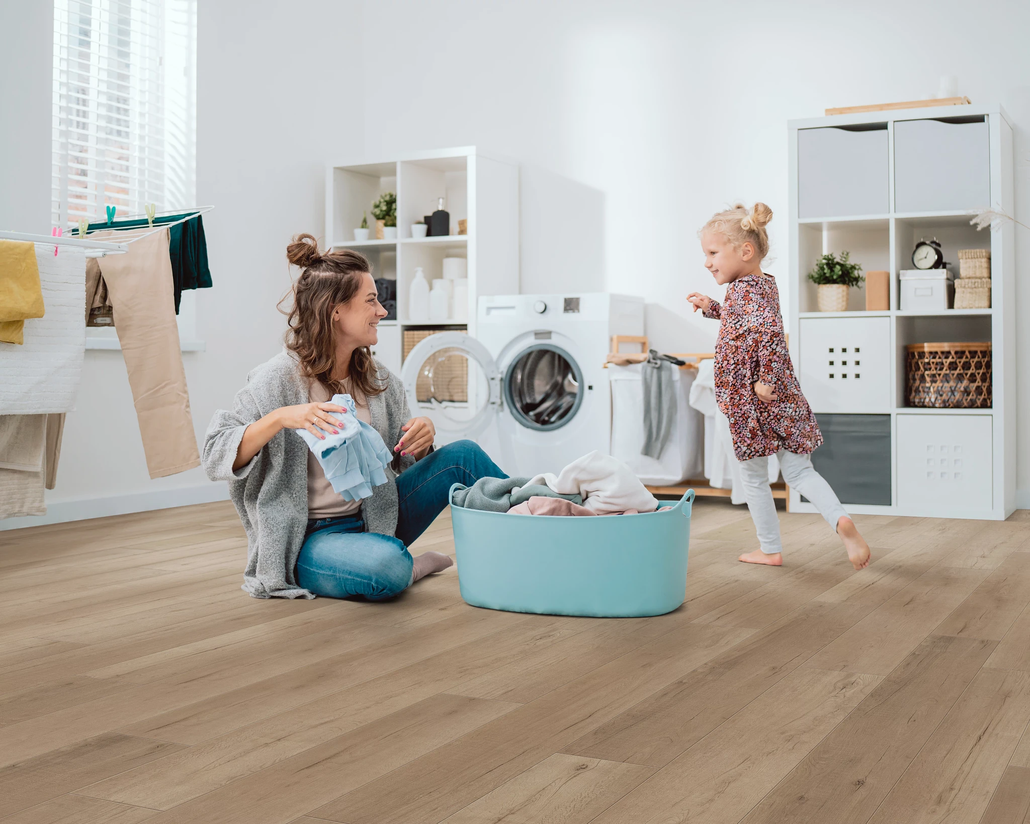 laundry room with luxury vinyl plank floor in a wood look with a young woman and child