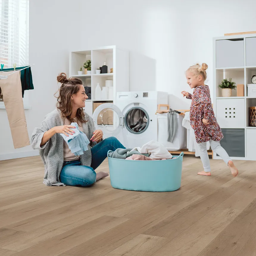 Coretec Residential WPC Luxury Vinyl Plank Flooring in Laundry Room - 48.03x7.09 inch laundry room with luxury vinyl plank floor in a wood look with a young woman and child
