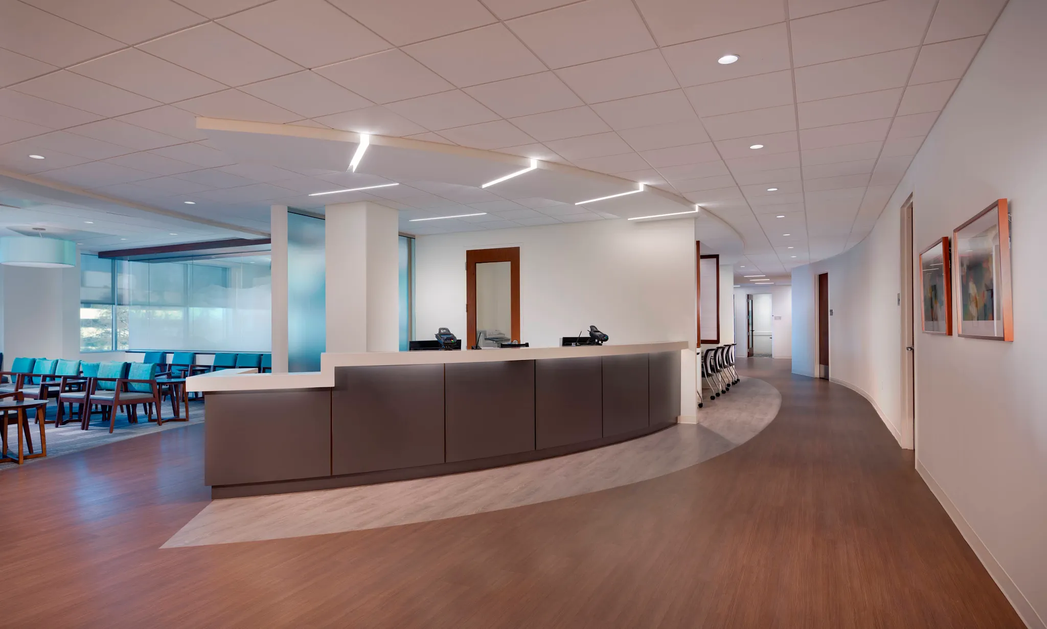 Healthcare facility with heavy commercial luxury vinyl tile flooring featuring a curved reception desk and seating area