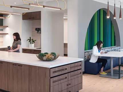 Stylish office kitchen design with elegant wood flooring Modern workplace kitchen with light wood flooring and contemporary furniture