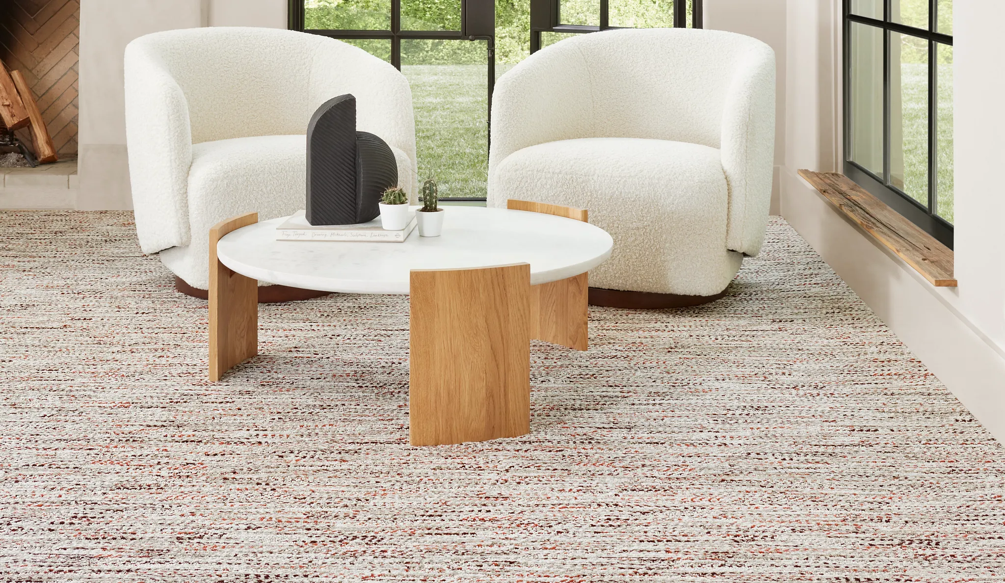 Modern living room with large arched windows, white armchairs, and a textured carpet flooring