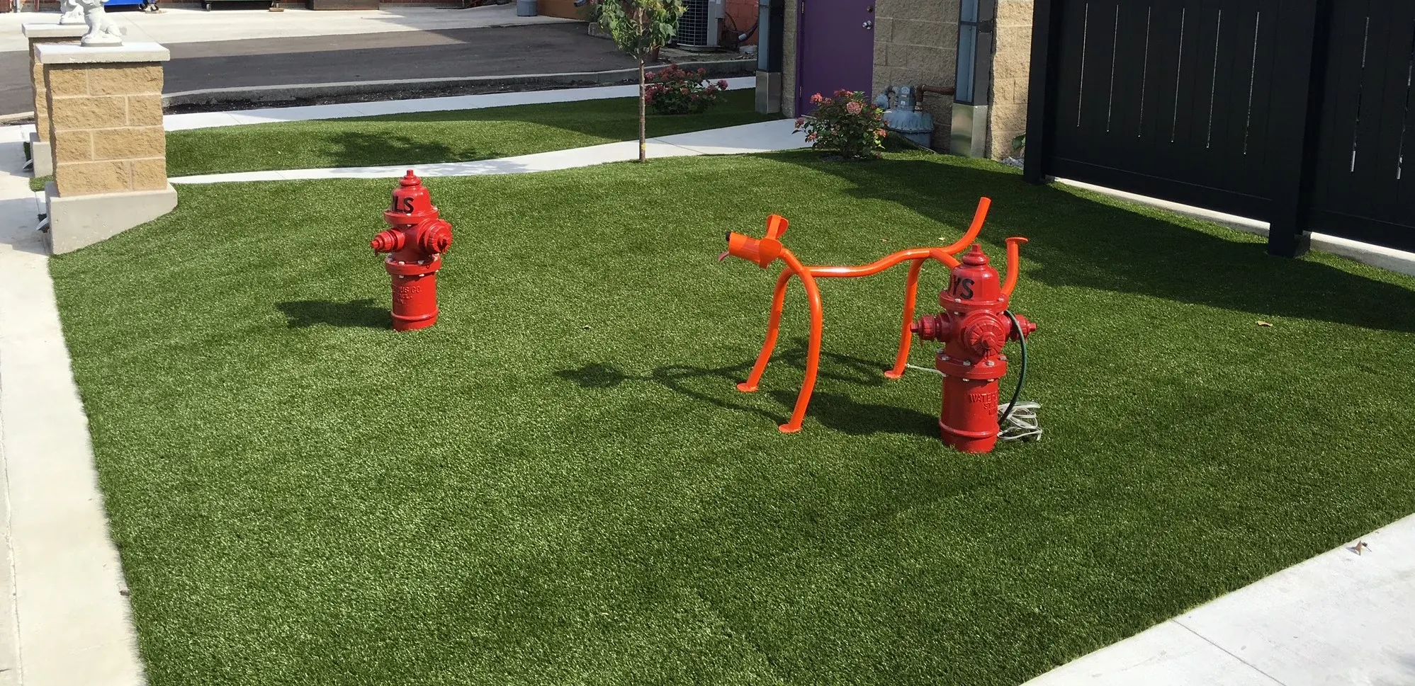 Artificial grass lawn with red hydrant and sculpture