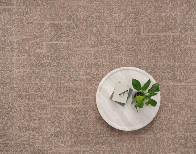 Broadloom carpet in earthy tones with round table and plant