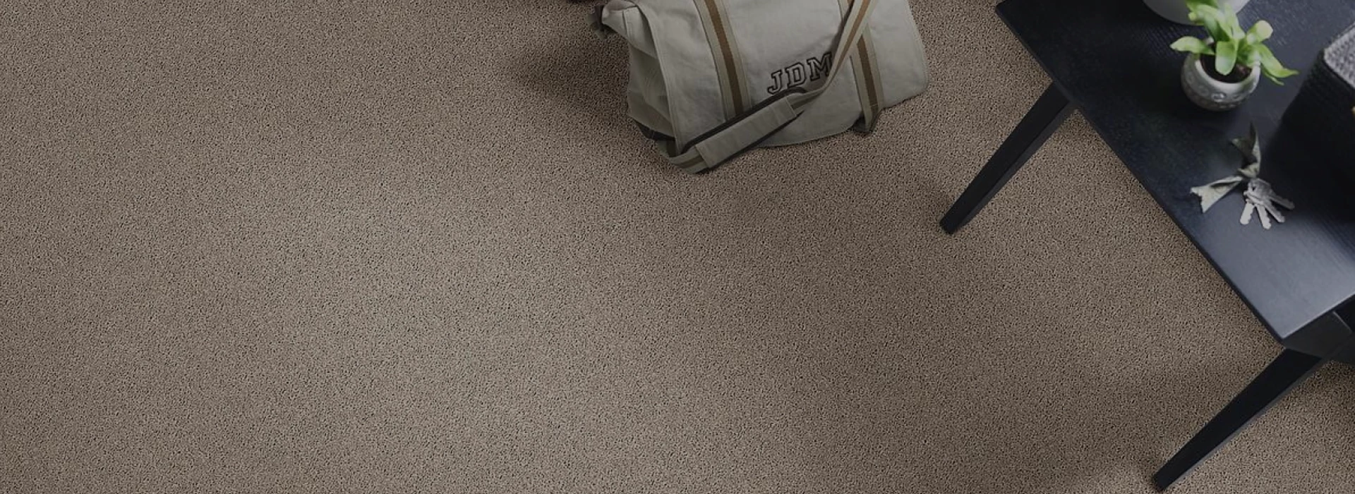 Carpet flooring with a bag and short desk on the side.