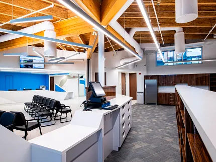 Retail Facility with Commercial Carpet Tile Flooring and Modern Design Modern retail facility with commercial carpet tile flooring, featuring a spacious layout with wooden ceiling beams and contemporary furniture.