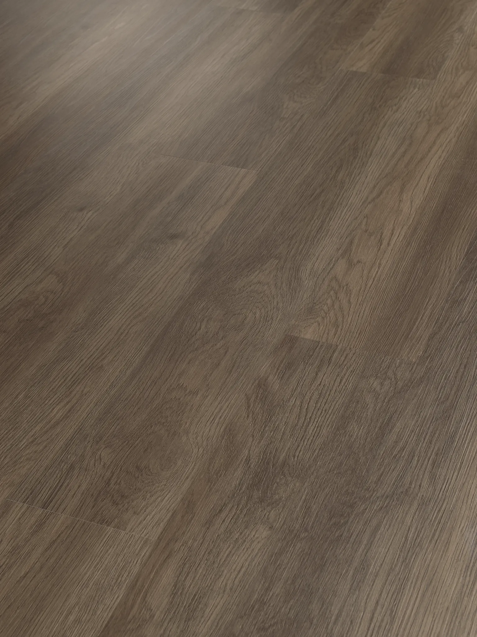 Luxury vinyl plank flooring with wood grain texture in brown tones