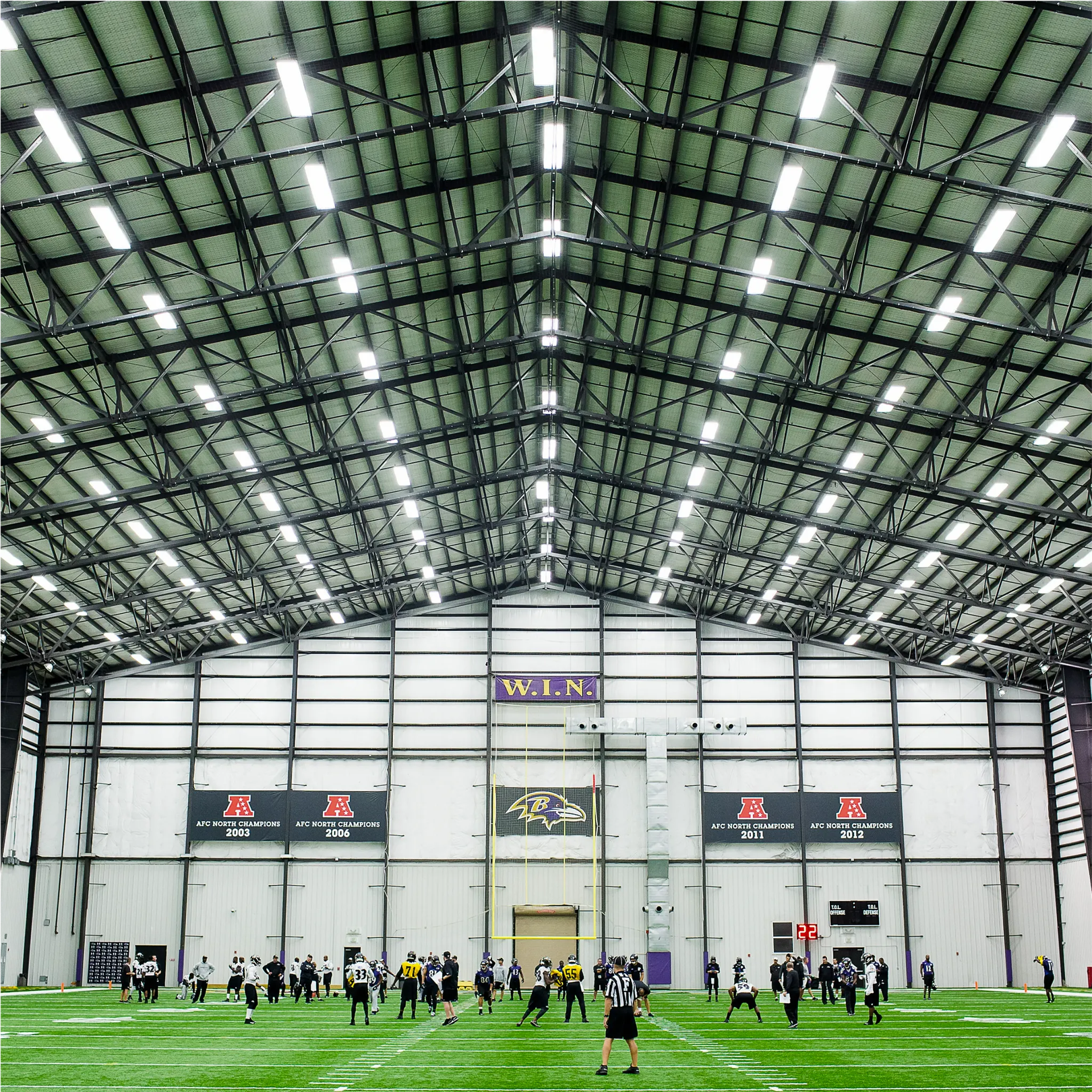 Baltimore Ravens logo over indoor sports facility with artificial turf