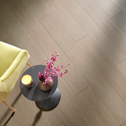 Light Wood Look Luxury Vinyl Plank Flooring in Modern Living Room Scene Modern living room with light wood look luxury vinyl plank flooring, featuring a yellow chair and a small round table with a pink orchid and candle.