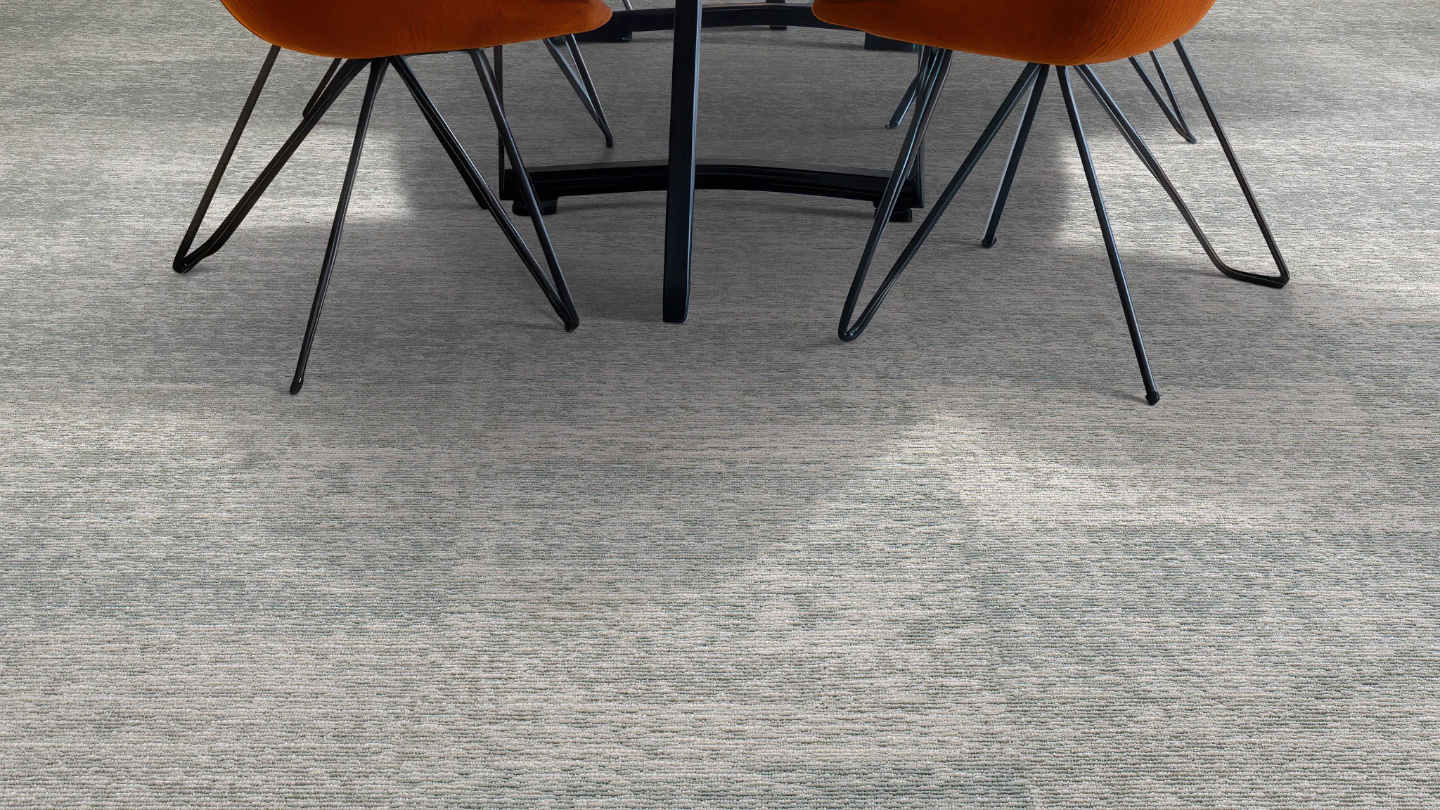Modern office space with gray commercial carpet tile, featuring a contemporary chair and side table