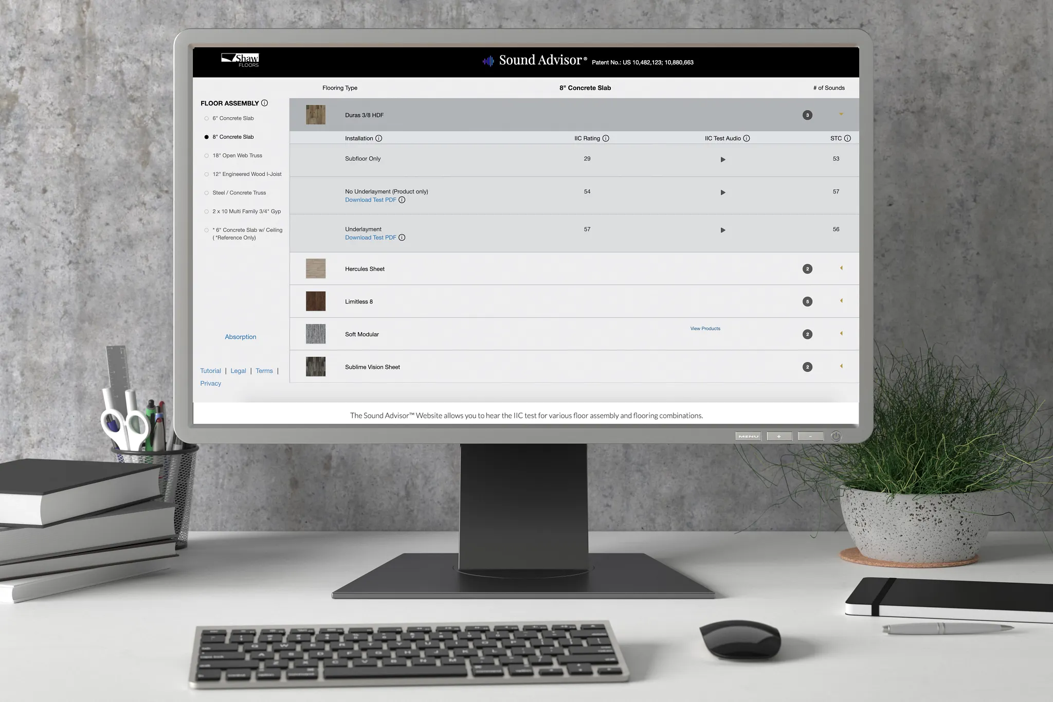 Modern office desk setup with computer displaying Sound Advisor website for flooring options
