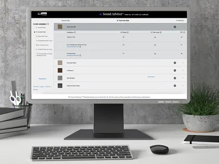 Office desk with Sound Advisor flooring options on computer screen Modern office desk setup with computer displaying Sound Advisor website for flooring options