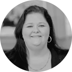 Black and white image of a woman with long dark hair wearing hoop earrings and a necklace