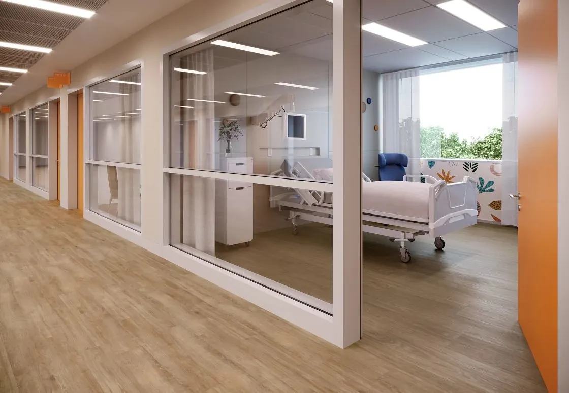 Healthcare facility hallway with light wood-look flooring and patient room