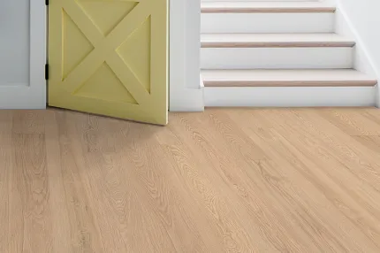 Durable light oak laminate flooring for a welcoming home environment Light oak laminate flooring in a cozy home entryway with a yellow barn door and white stairs