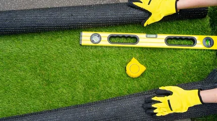 Easy artificial grass installation for outdoor spaces Installation of artificial grass with measuring tools and gloves