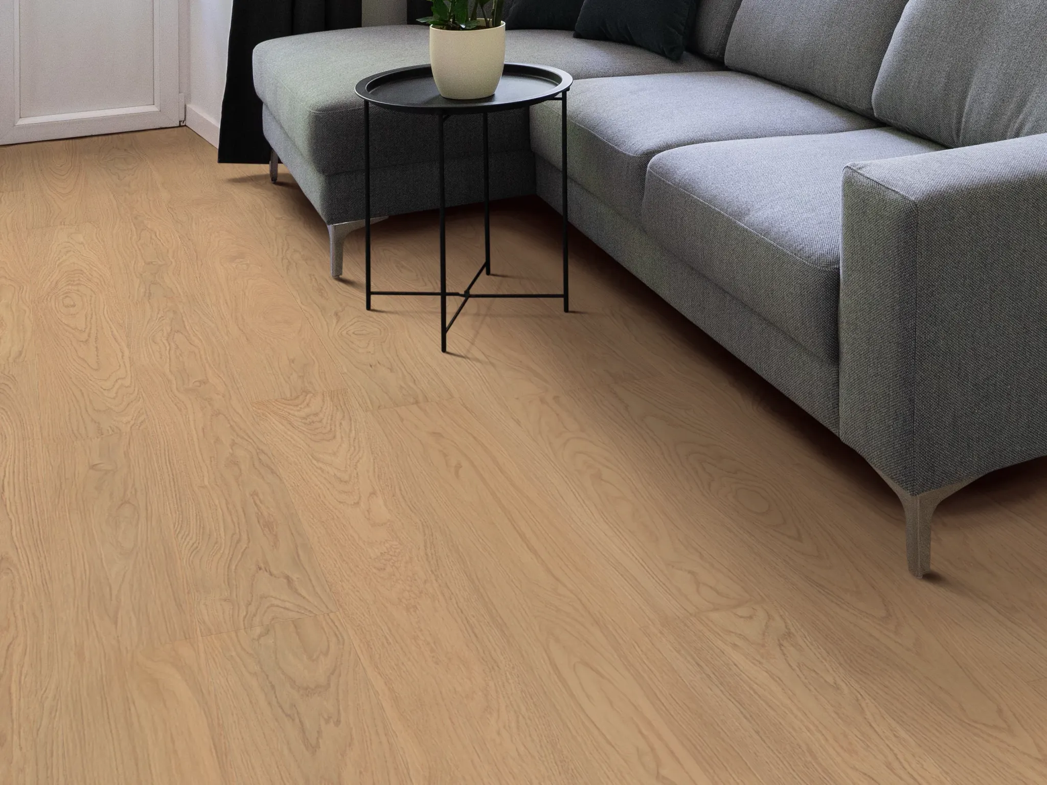 Cozy living room with light wood laminate flooring and a modern gray sofa