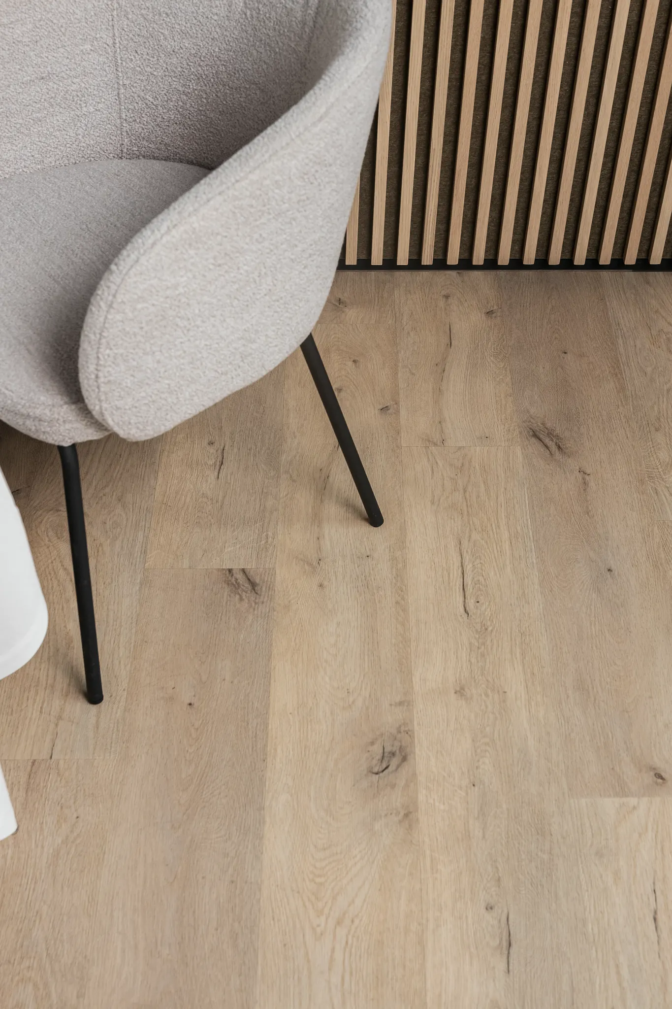 Modern living room with wood look vinyl flooring and beige chair