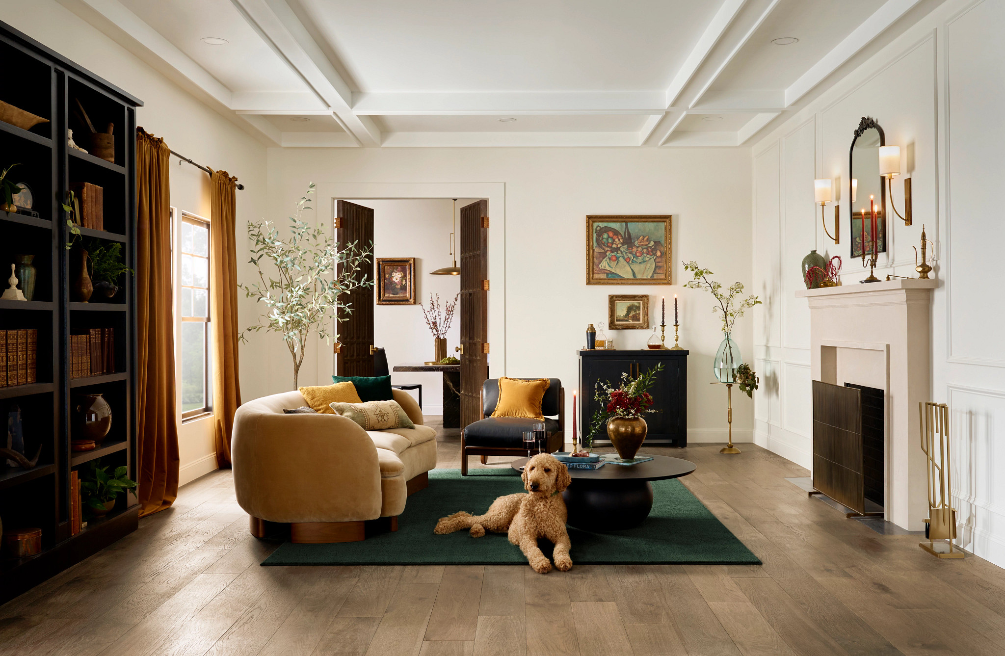 A dog sits on a green rug over hardwood in an ecclectic living room.