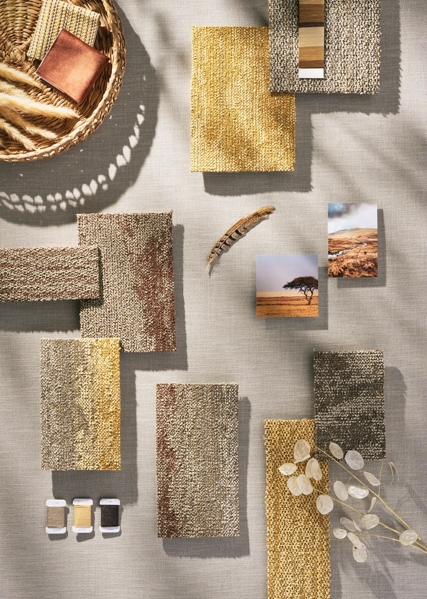 Assorted carpet swatches in shades of yellow, brown, and beige with natural elements and landscape photos