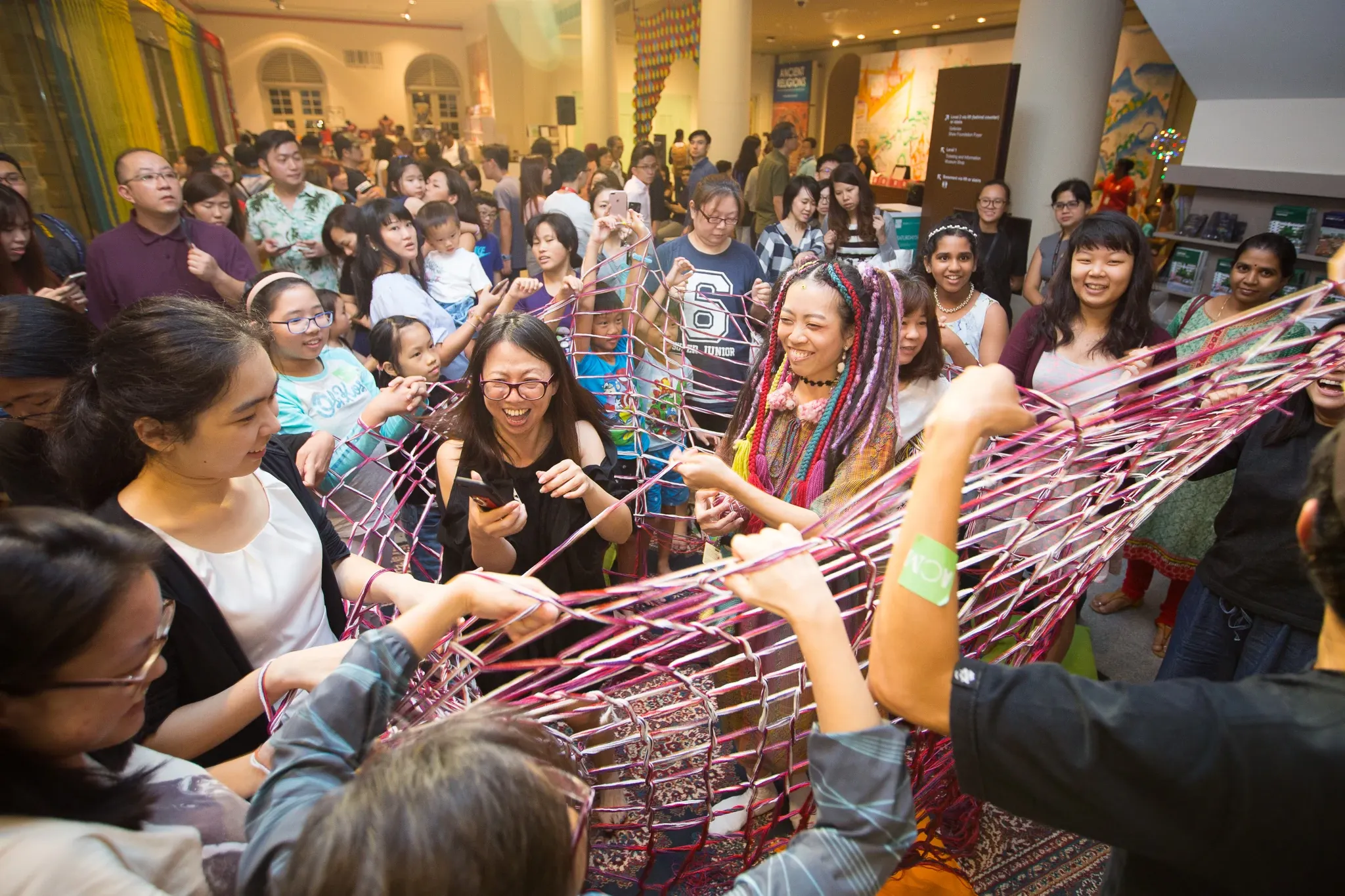 Group of people engaging in a colorful interactive art installation in a public space
