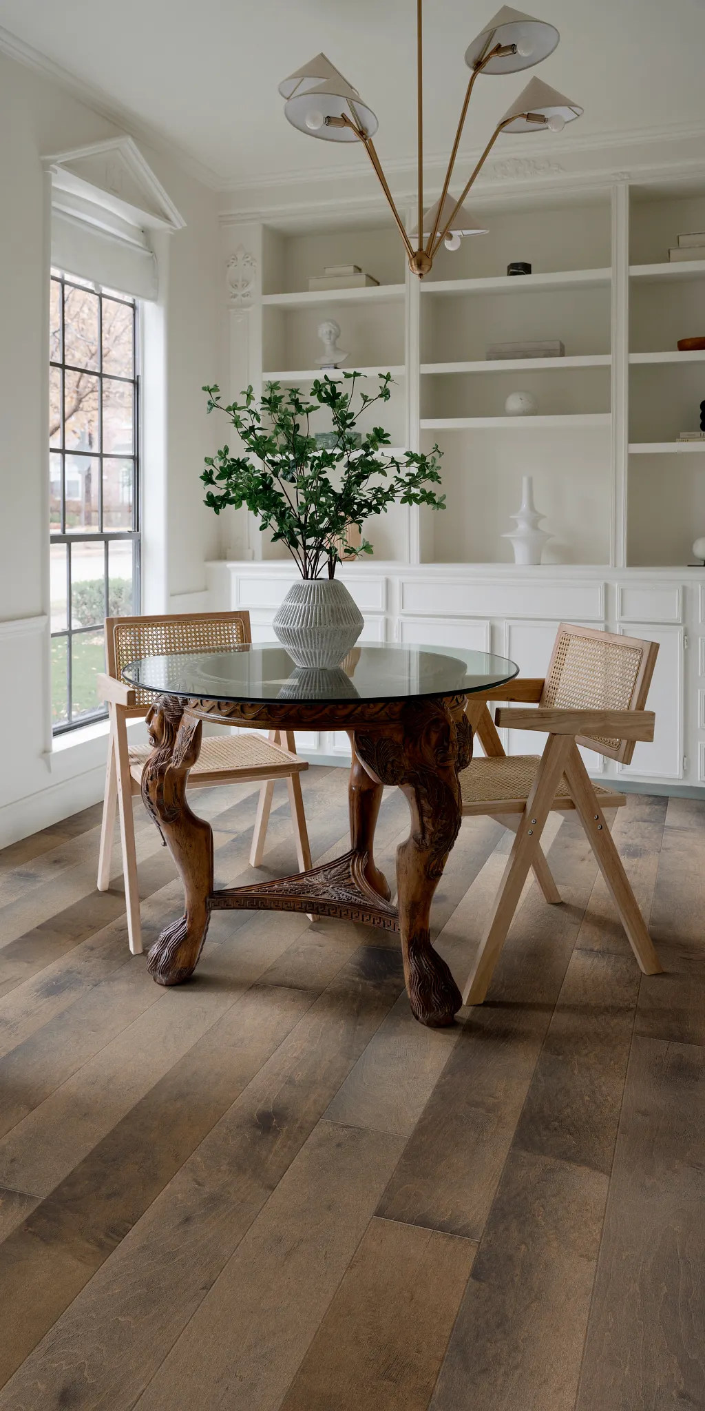 Elegant dining room with hardwood flooring featuring a glass table and wooden chairs