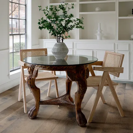 Hardwood flooring in a stylish dining room setting Elegant dining room with hardwood flooring featuring a glass table and wooden chairs