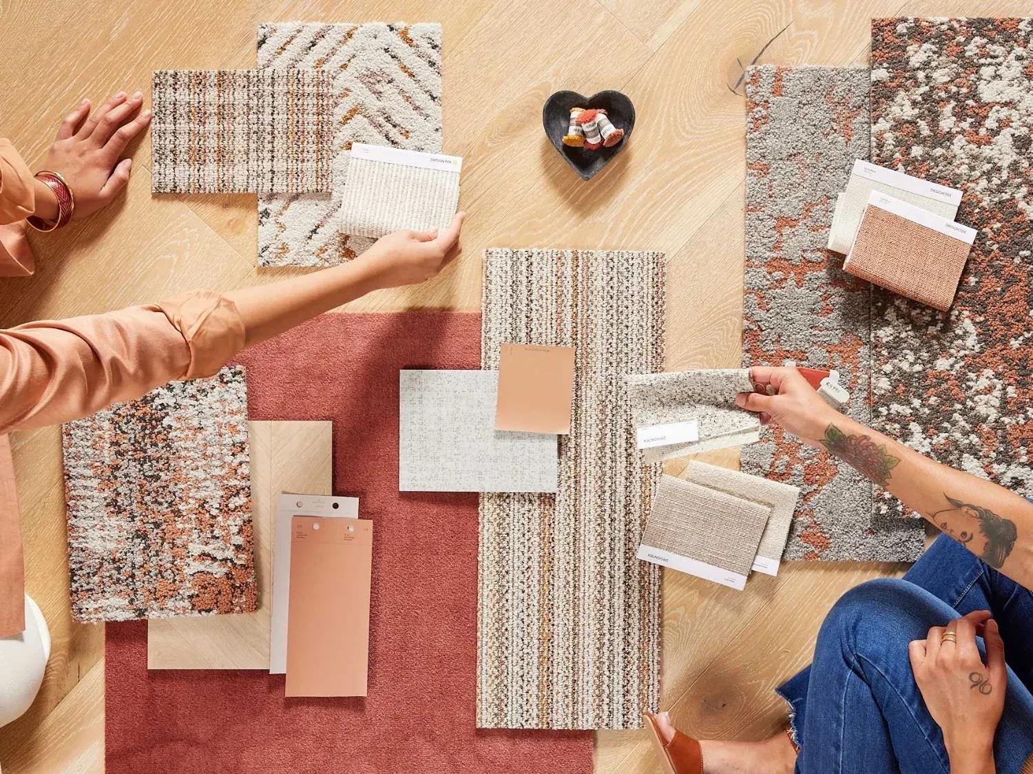Assorted carpet swatches in various colors with people selecting samples