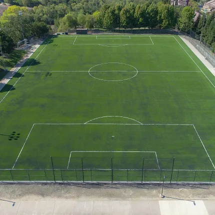 Artificial Turf Soccer Field Aerial View Aerial view of a large artificial turf soccer field surrounded by trees and pathways