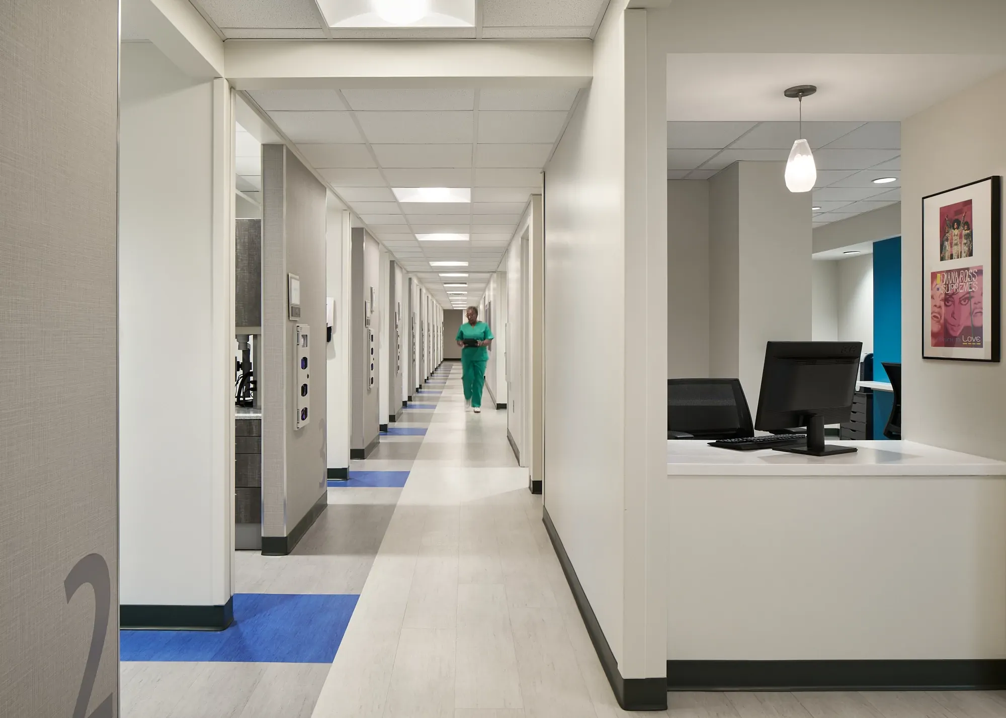 Modern hospital corridor with light and blue flooring