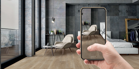 Person holding a mobile phone to view their room with a new floor visualized.