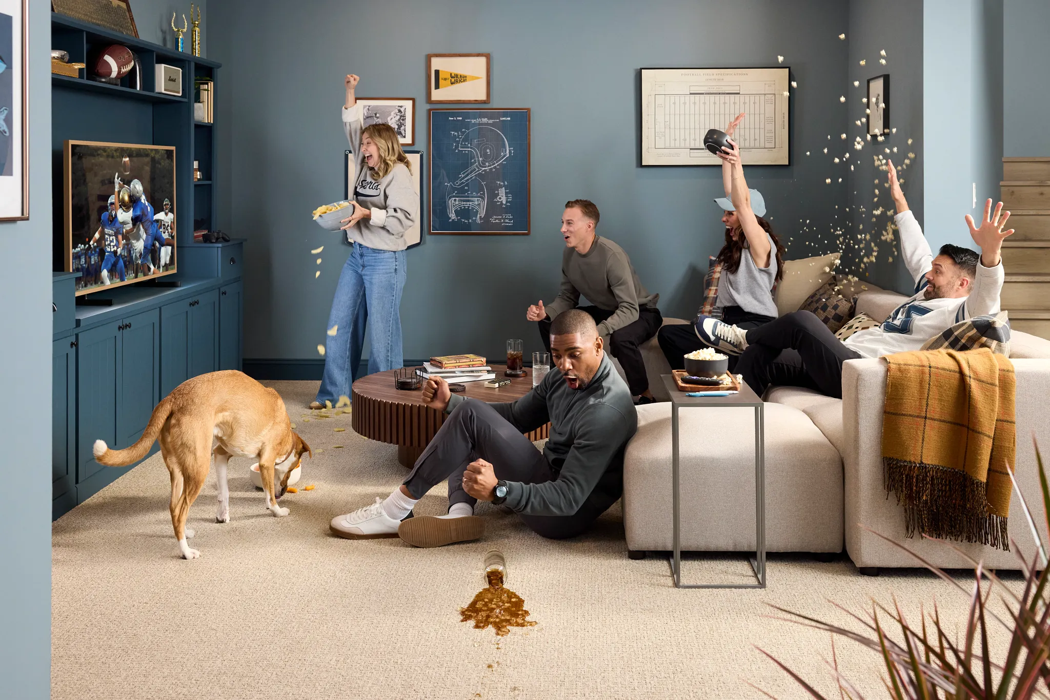 Cozy living room scene with a group of people enjoying a game on TV, featuring durable and easy-to-clean carpet flooring ideal for everyday lifestyle and comfort