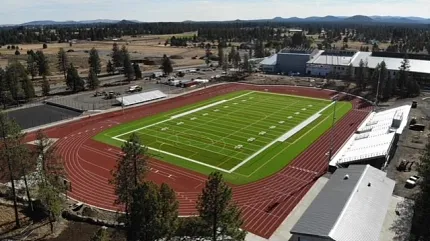 Sports stadium with artificial turf and running track Aerial view of a sports stadium featuring artificial turf on the field surrounded by a red running track