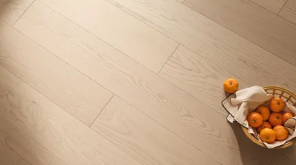 Overhead view of blonde hardwood flooring with a basket of oranges sitting on top.