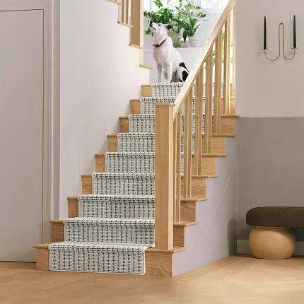 Black and white patterned synthetic carpet on stairs with dog Synthetic carpet on staircase with black and white pattern and a dog
