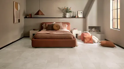 Coretec Mineral Core Residential LVT Flooring in Bedroom - 23.62x11.81 inch bedroom with Mineral Core Residential luxury vinyl tile floor in a light stone look with a bed and warm decor