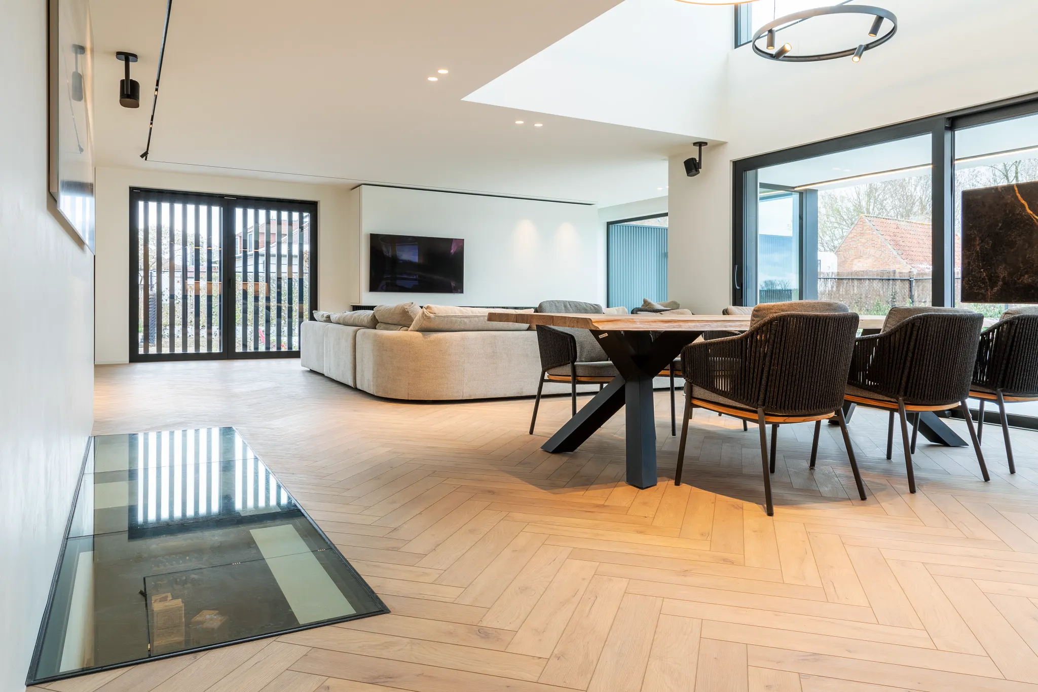 Modern living room with light wood herringbone flooring