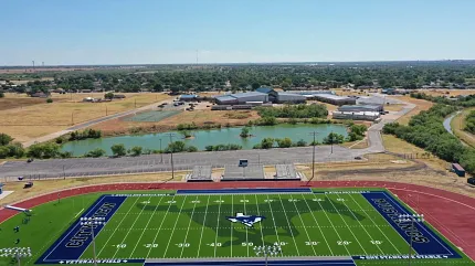 Artificial Turf Sports Field with Running Track Aerial View Aerial view of a sports field with artificial turf surrounded by a running track