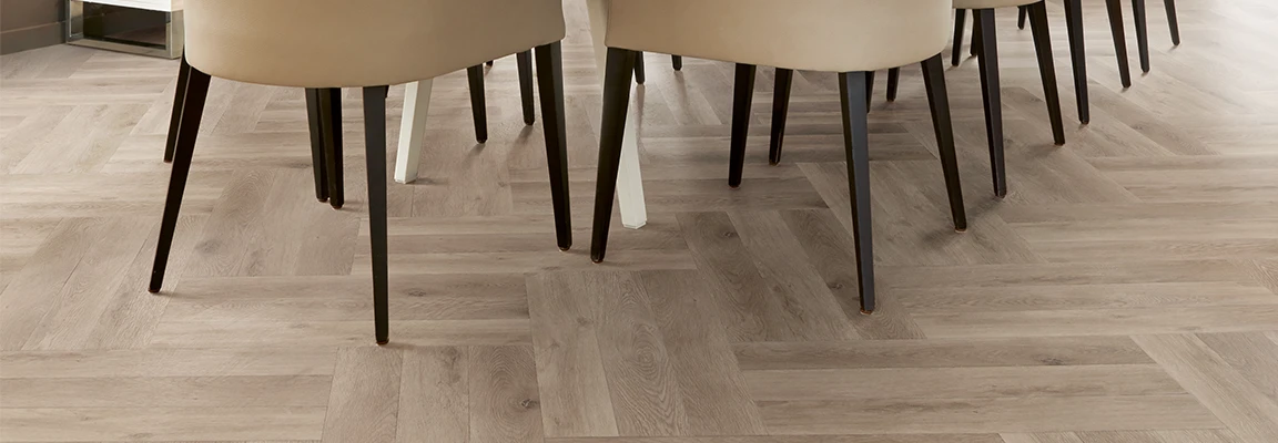 Modern dining room with beige chairs on light wood look luxury vinyl plank flooring