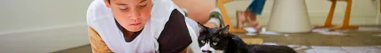 Wood Look Luxury Vinyl Plank Flooring in a Family Room Scene Child reading with a cat on wood look luxury vinyl plank flooring in a bright room
