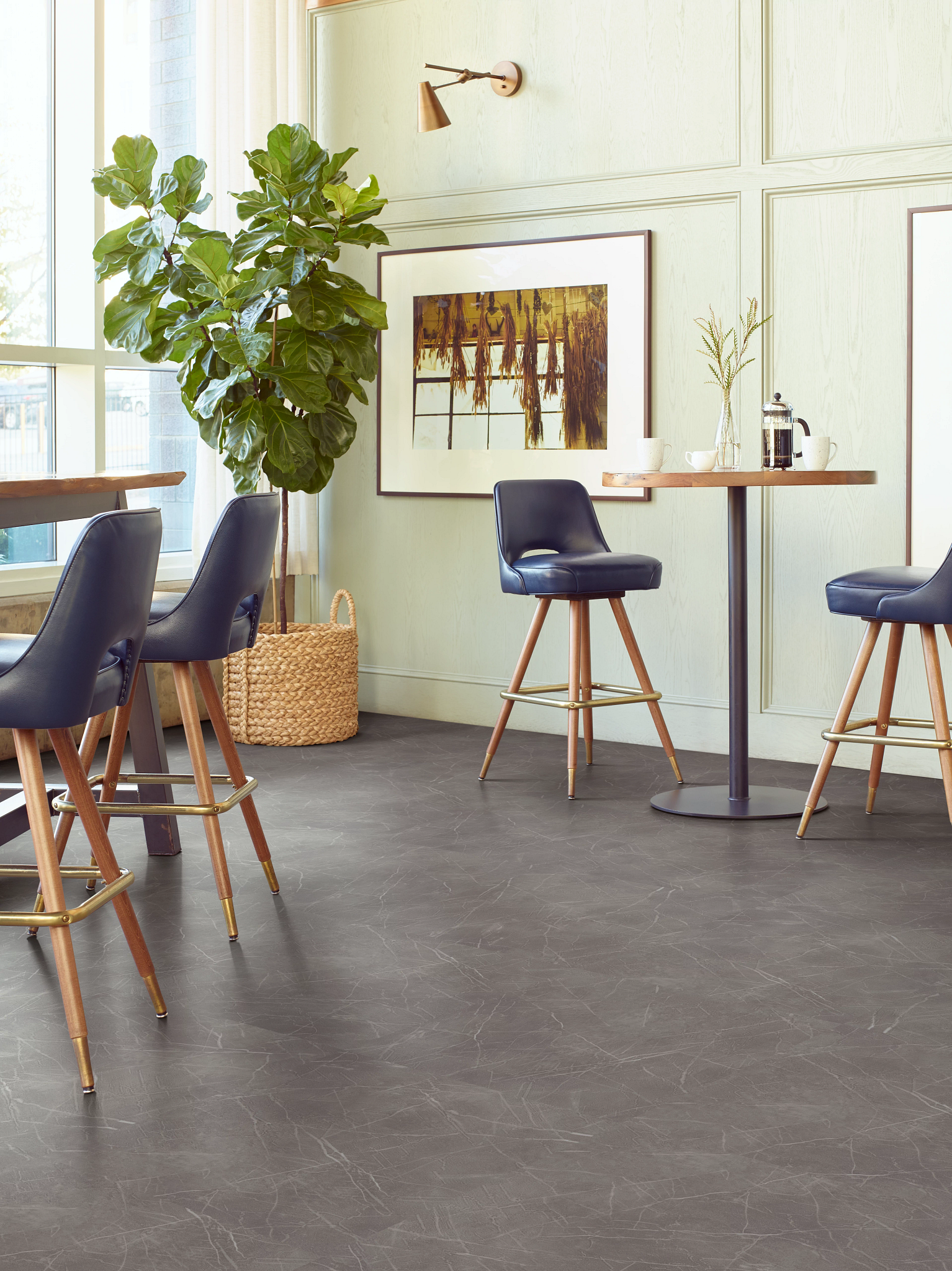 
  "dining area with dark gray tile floor with blue leather chairs and a potted plant for stylish home setting"
)