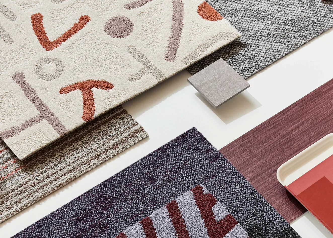 Assorted carpet swatches in beige, gray, and burgundy colors