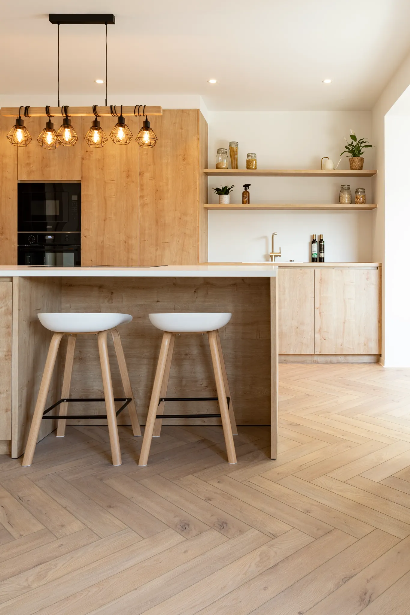 Country kitchen with wooden herringbone flooring and kitchen island