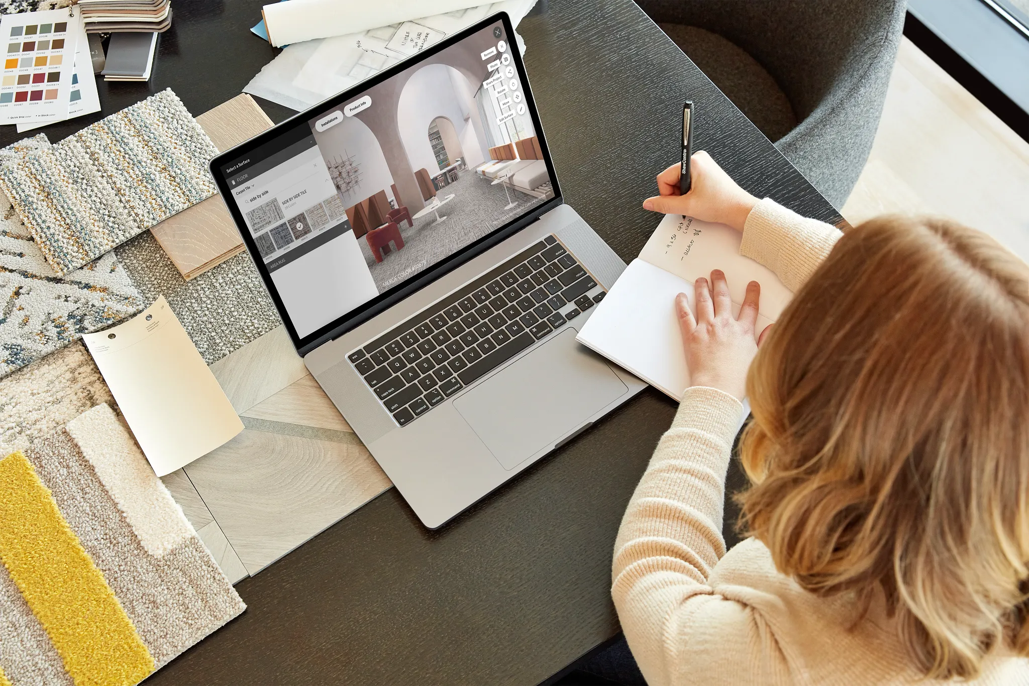 Woman designing with flooring swatches and laptop displaying interior design